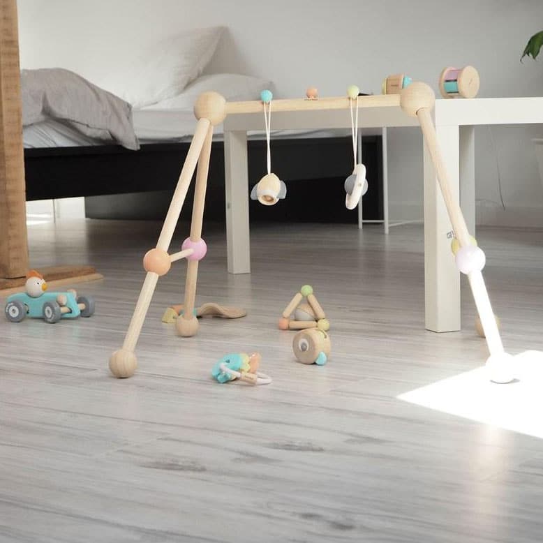Quarto com brinquedos nos chão e elemento decorativos do Ginásio Bebé Madeira - Play Gym Pastel Collection Plan Toys®