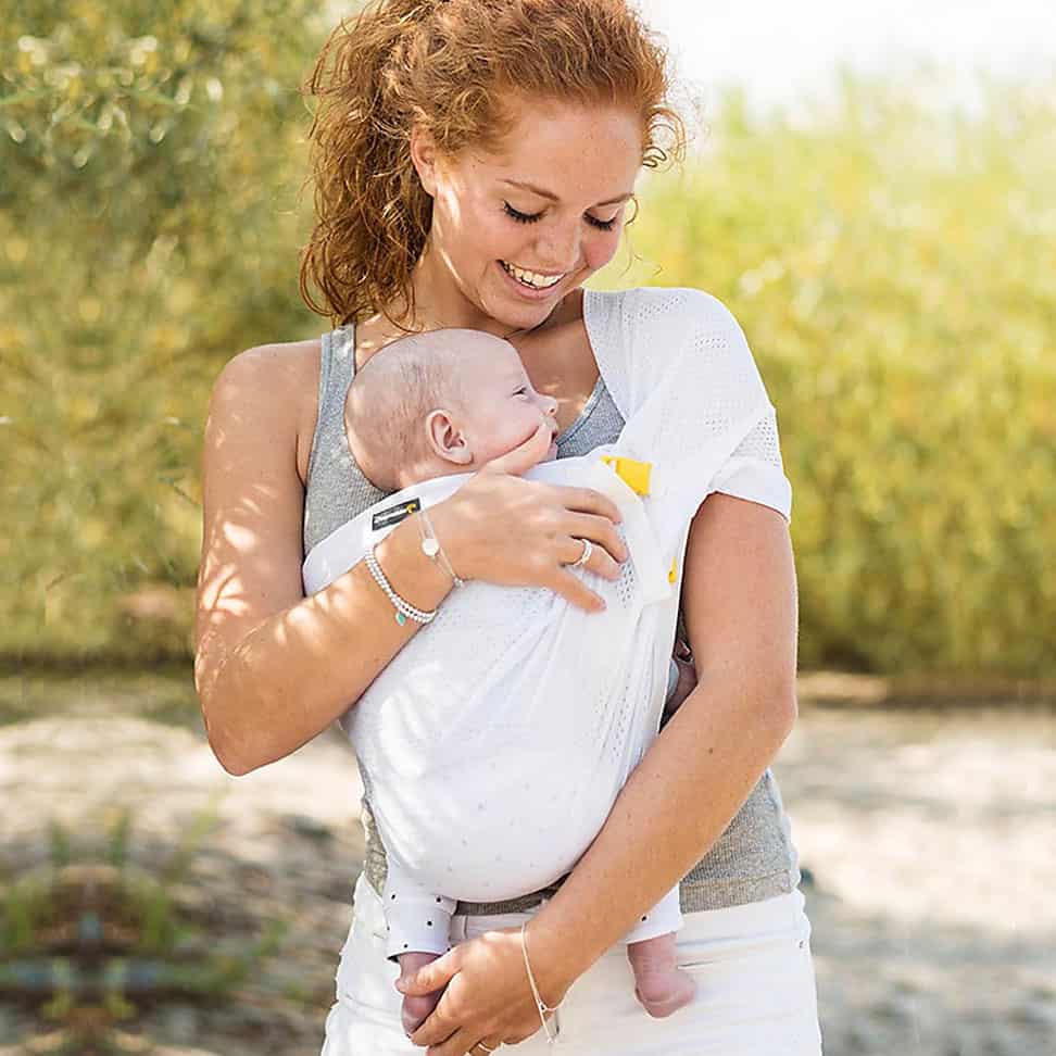 Mãe a abraçar bebé no Mini Sling Minimonkey - Branco