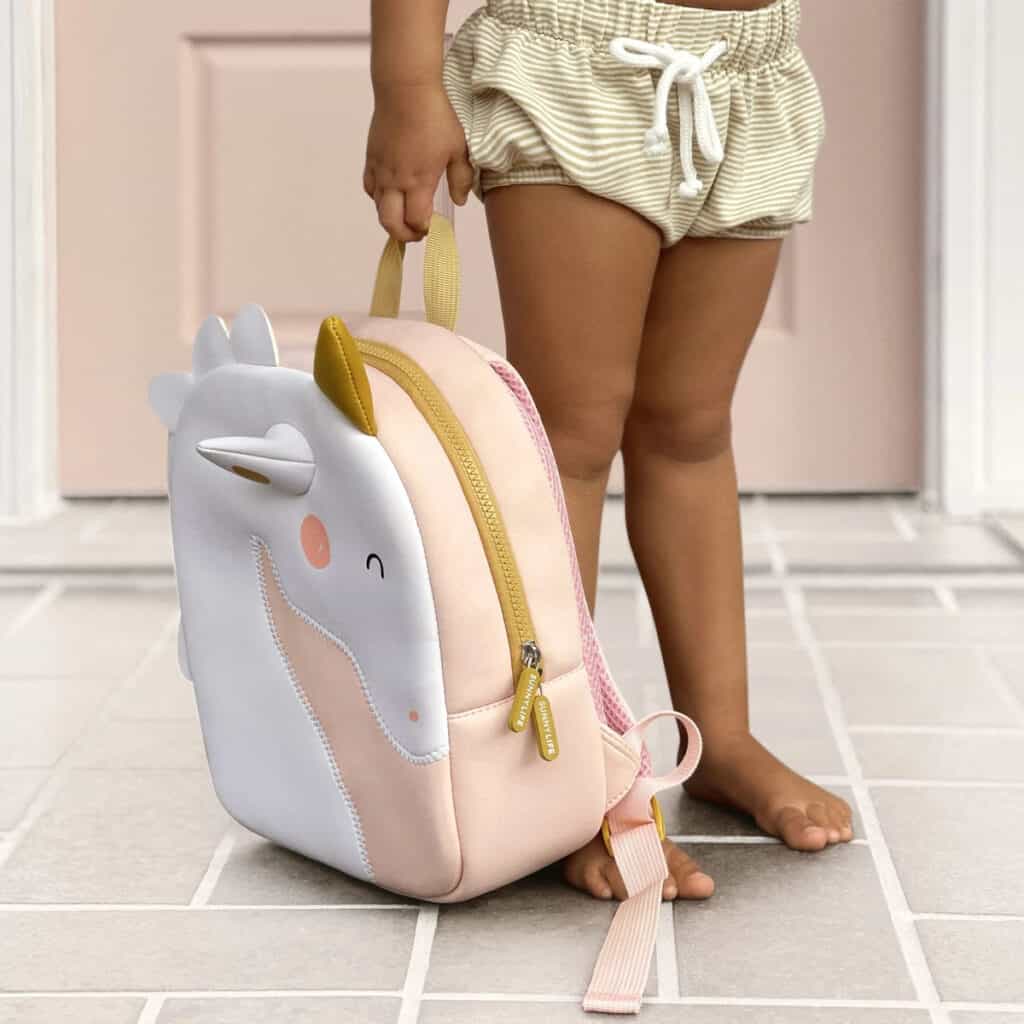 Criança em idade pré escolar segura pela alça de mão a mochila em neoprene Sunnylife®