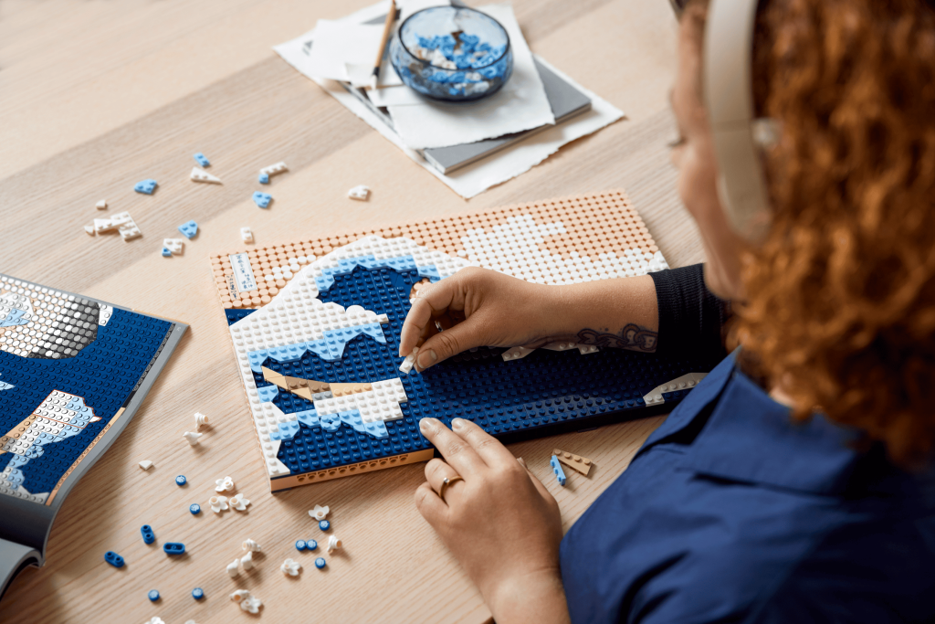 Babystore.pt - Bens para Bebés e Crianças de 0 a 6 Anos Pessoa a montar o quadro LEGO Art 31208 Hokusai – A Grande Onda